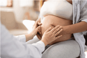 zwangere buik met zorgverlener